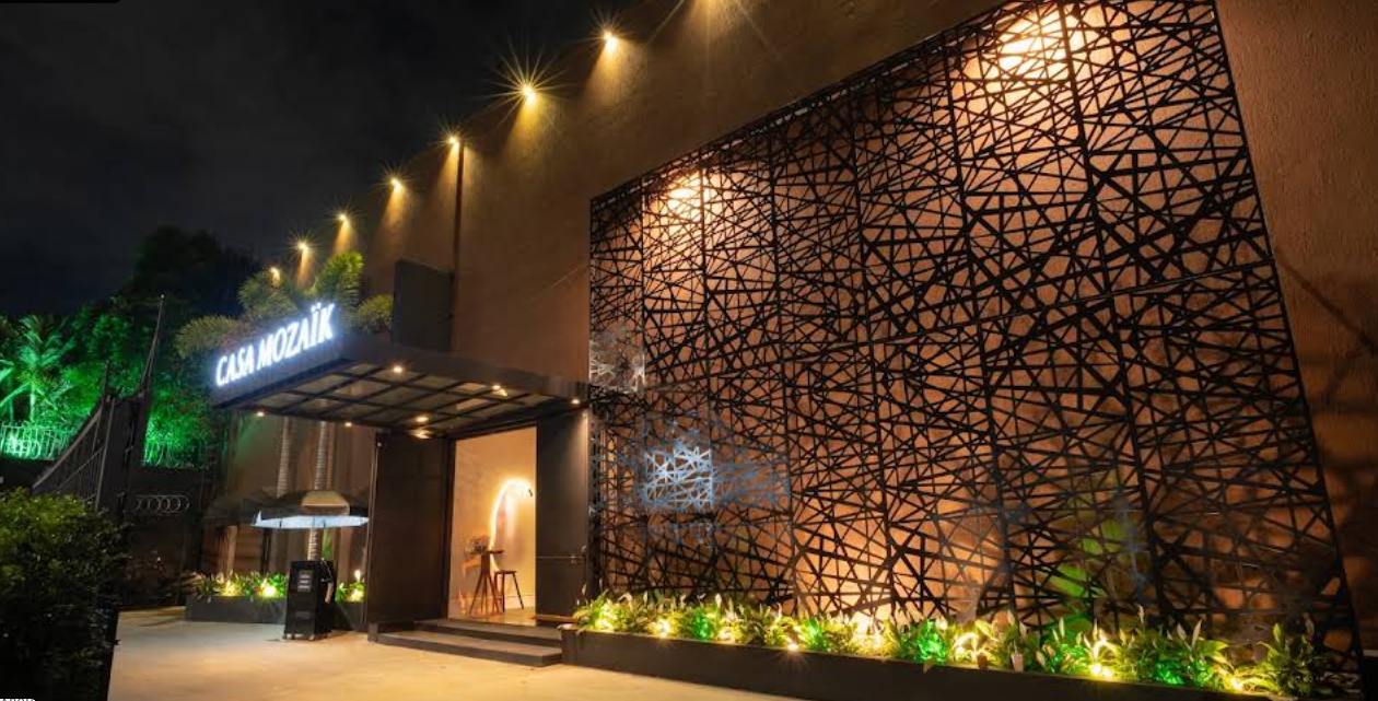 Fachada iluminada da entrada da Casa Mozaik à noite