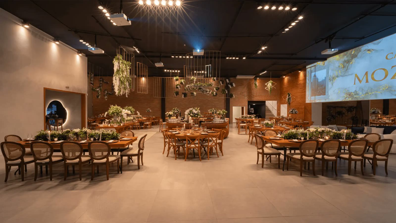 Salão da Casa Mozaik com mesas postas e decoração floral